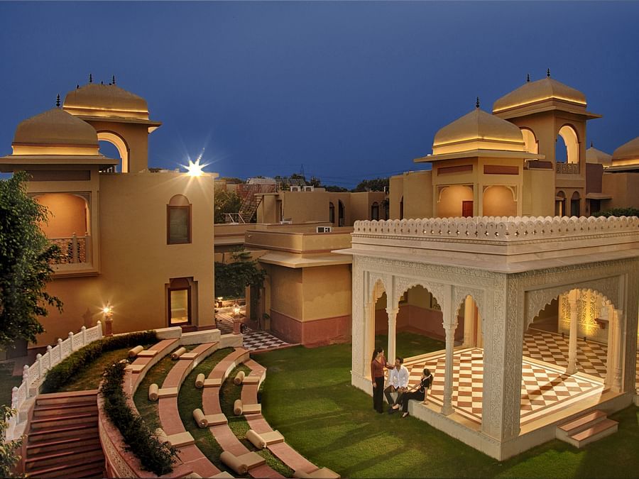  An open-air amphitheatre and traditional pavilion set amidst a serene courtyard at dusk -  Heritage Village Resorts & Spa, Manesar