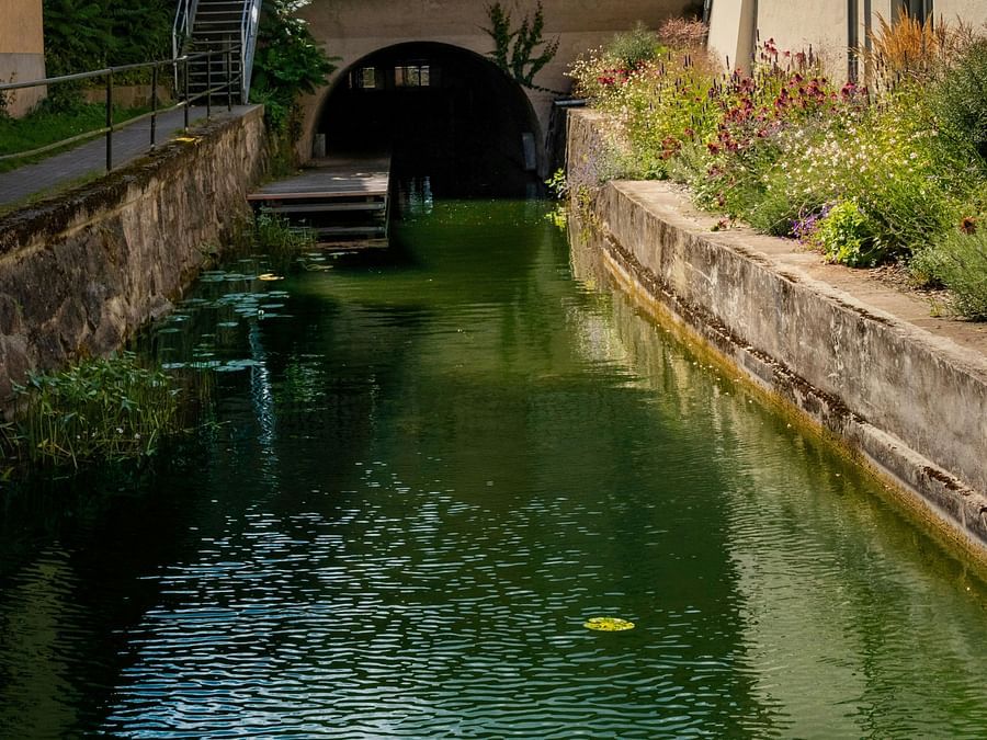 Shot of a tunnel river flowing with boundary walls on either sides.