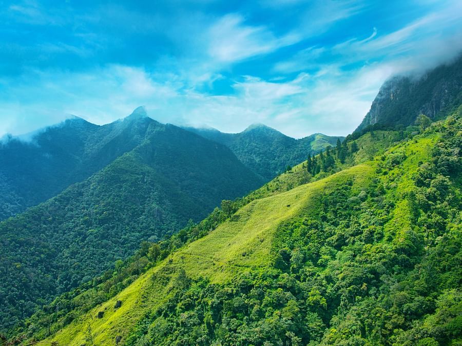 green mountains covered by while clouds