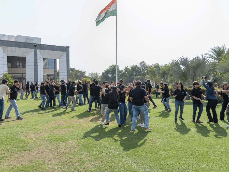A group of people playing a game near the flagpole - Karma Lakelands.
