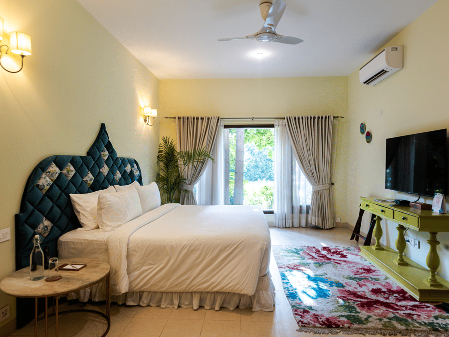 A suite of the Kingfisher Villa with a double bed and side tables - Karma Lakelands.