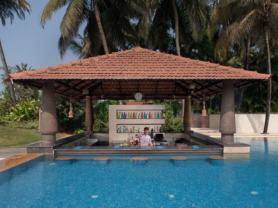 Our pool-side cafe in South Goa, Aquarius, looks dream-like as it resembles a gazebo coming out of the pool in a lush green backdrop