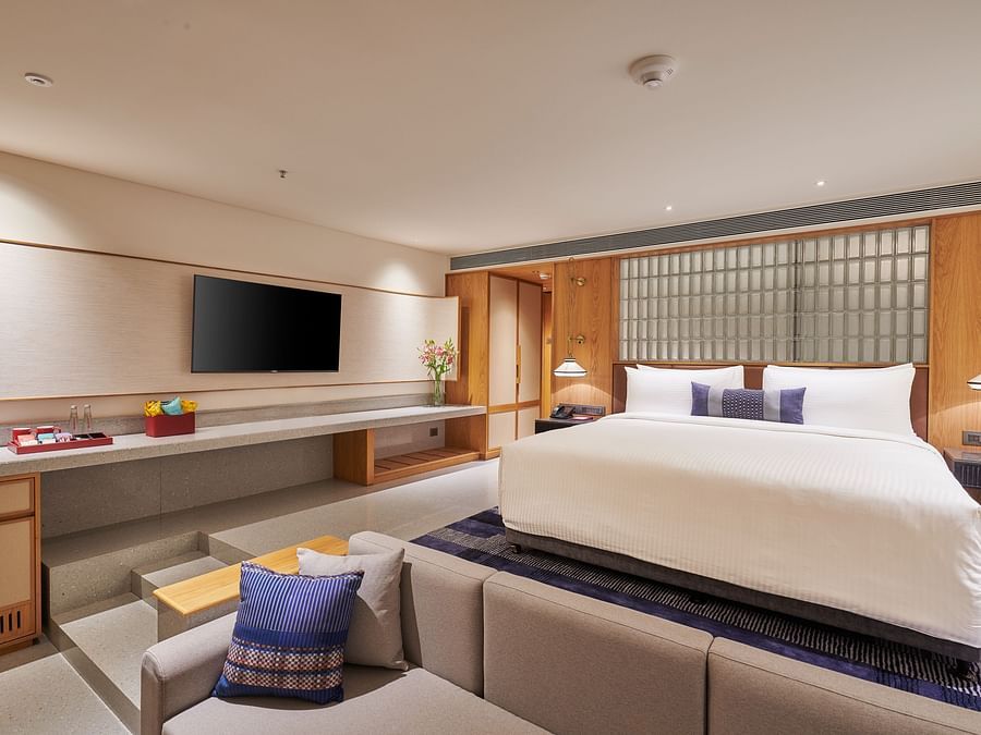 Image of a bedroom with a television, king side bed and a foot sofa in front of the bed  at The Dukes Retreat.