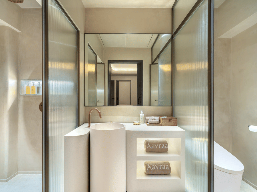 Bathroom of a room at The Residency Towers Chennai featuring a vanity separated by a glass panel from toilet and showering place