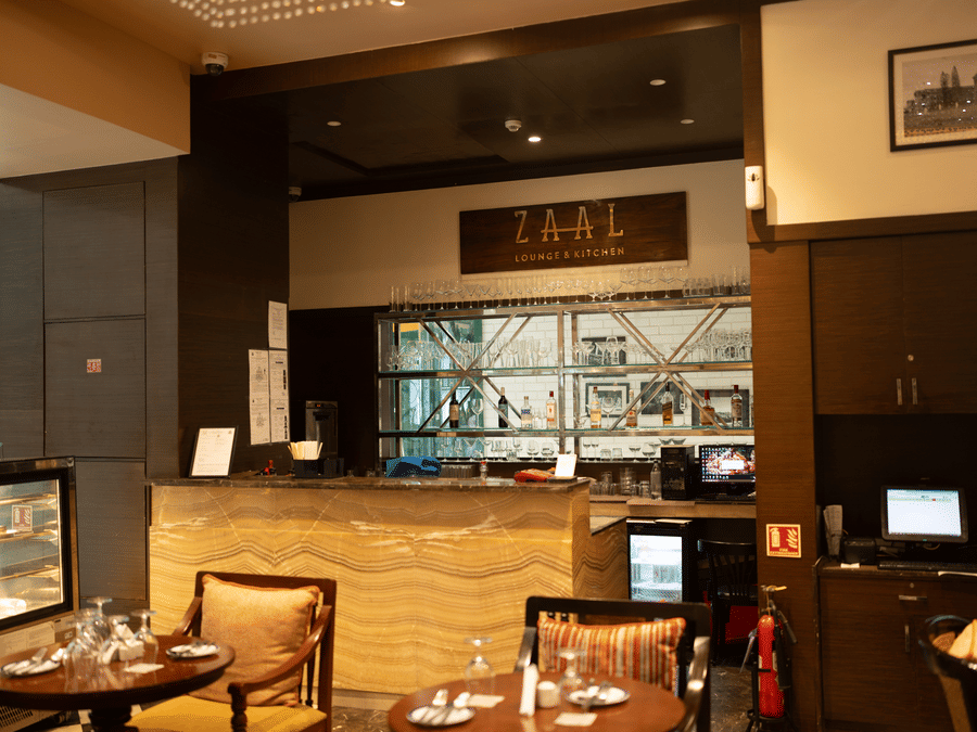 Fine dining interior with bar display and wooden furniture at Zaal Lounge & Kitchen, Whitefield Bengaluru