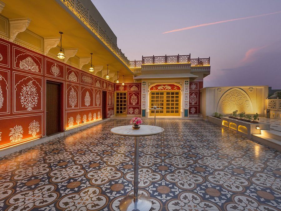 Ornate rooftop terrace with patterned tiles, decorated walls, and soft evening light - Heritage Village Resorts & Spa.