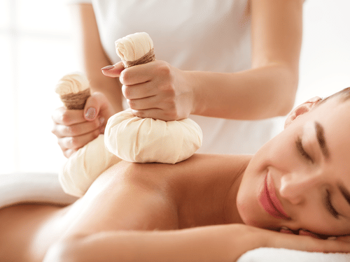 A woman recieving massage on her back while lying on her stomach at YO1 Longevity & Health Resorts