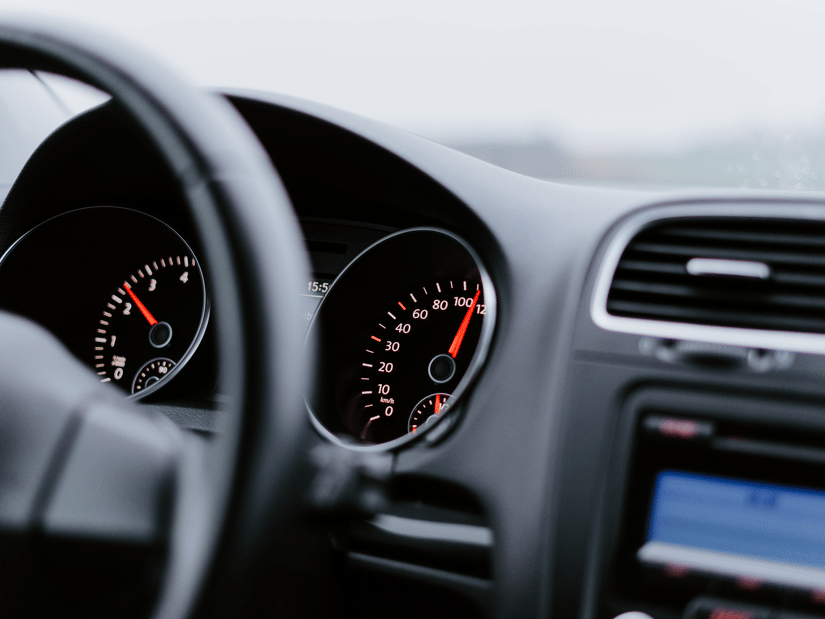 close up of a car front seat with stearing and the front board. 
