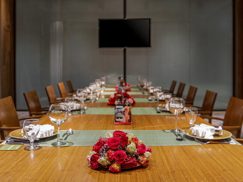 A close up shot of the dining table with many chairs and items kept on it inside FOGO NO CHÃO - Ramada by Wyndham Addis, Addis Ababa