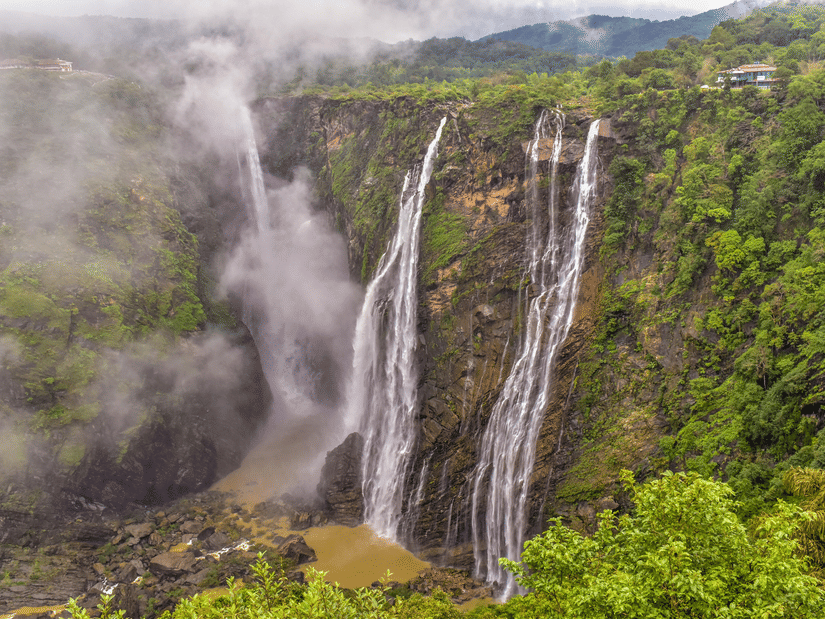 Scenic view of Jog Falls, India’s tallest waterfall, cascading down lush green cliffs amidst misty surroundings.