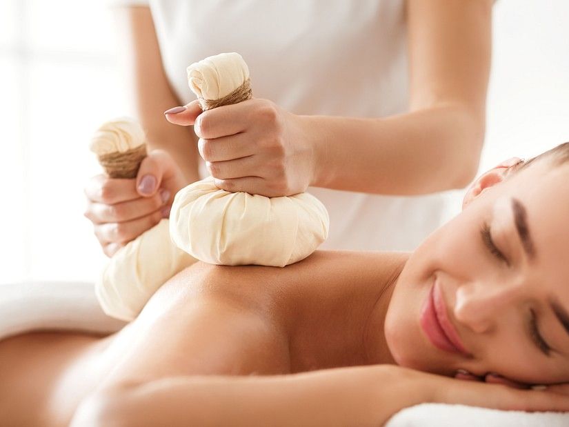 A woman recieving massage on her back while lying on her stomach
