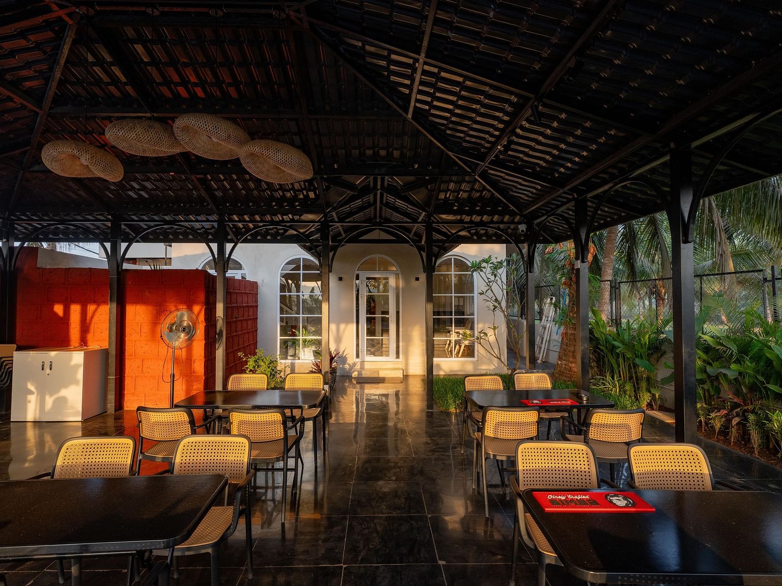 A partially enclosed outdoor dining area with a dark, peaked roof at Kssemya.