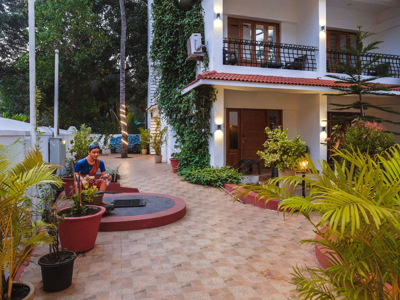 Spacious tiled courtyard with potted plants and a circular seating area at The Verda de Miranda Resort.
