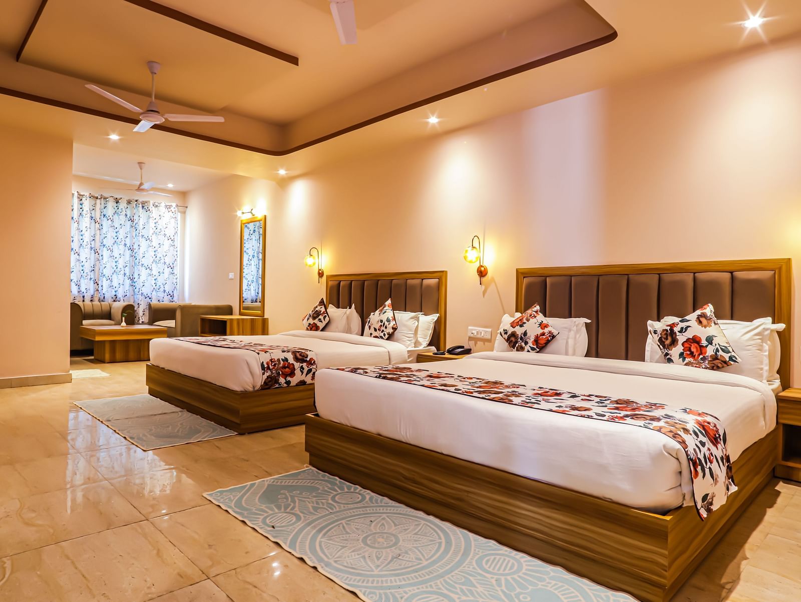 A comfortable bedroom at Vedikant Resorts The Mallard Corbett offers beds, a seating arrangement, and warm lighting.