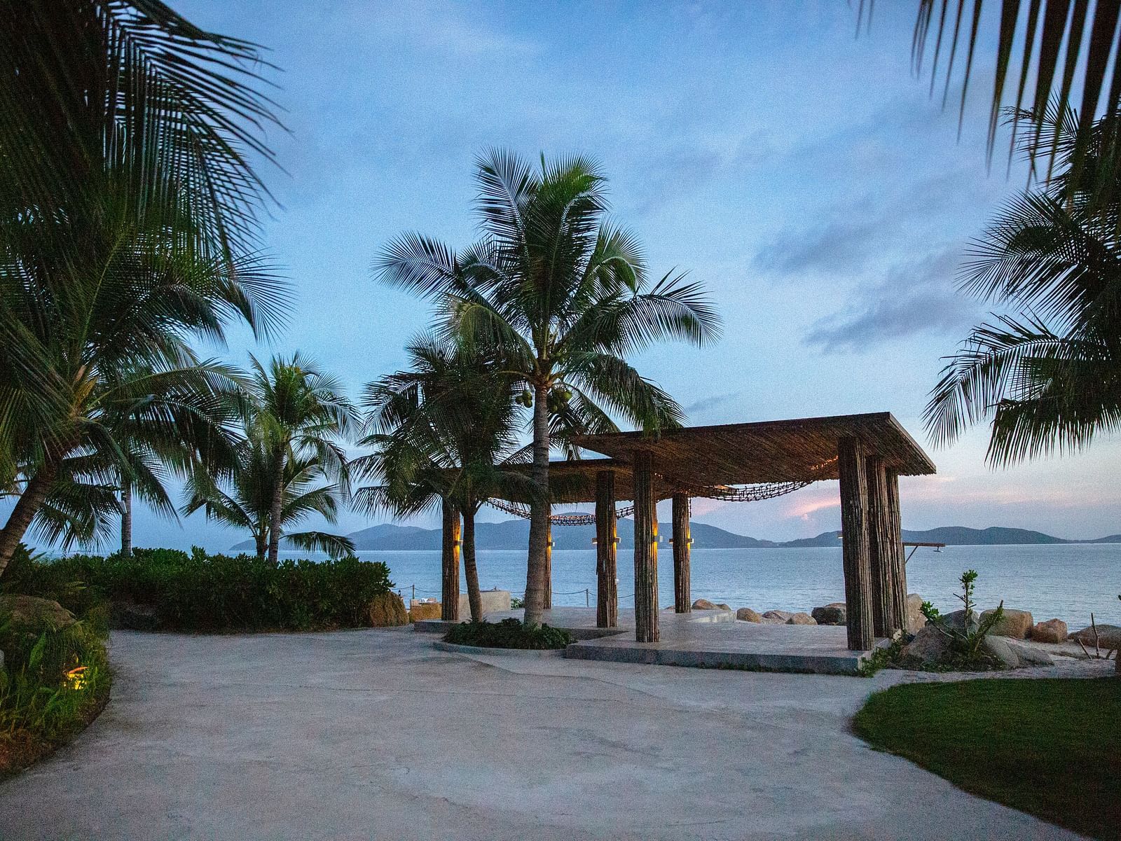 A serene setting covered by lush greenery by the bay of Nha Trang during a sunset - Alibu Resort Nha Trang