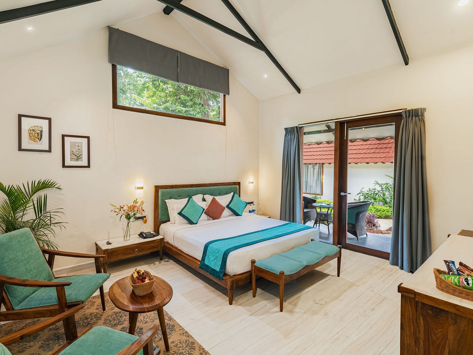 full view image from the corner of the luxury villa featuring a king size bed along with a full sized french windows at the far end of the room