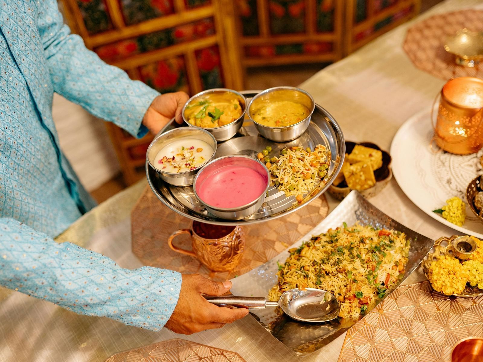 A traditional Indian thali meal, with a variety of vibrant dishes served in metal bowls.