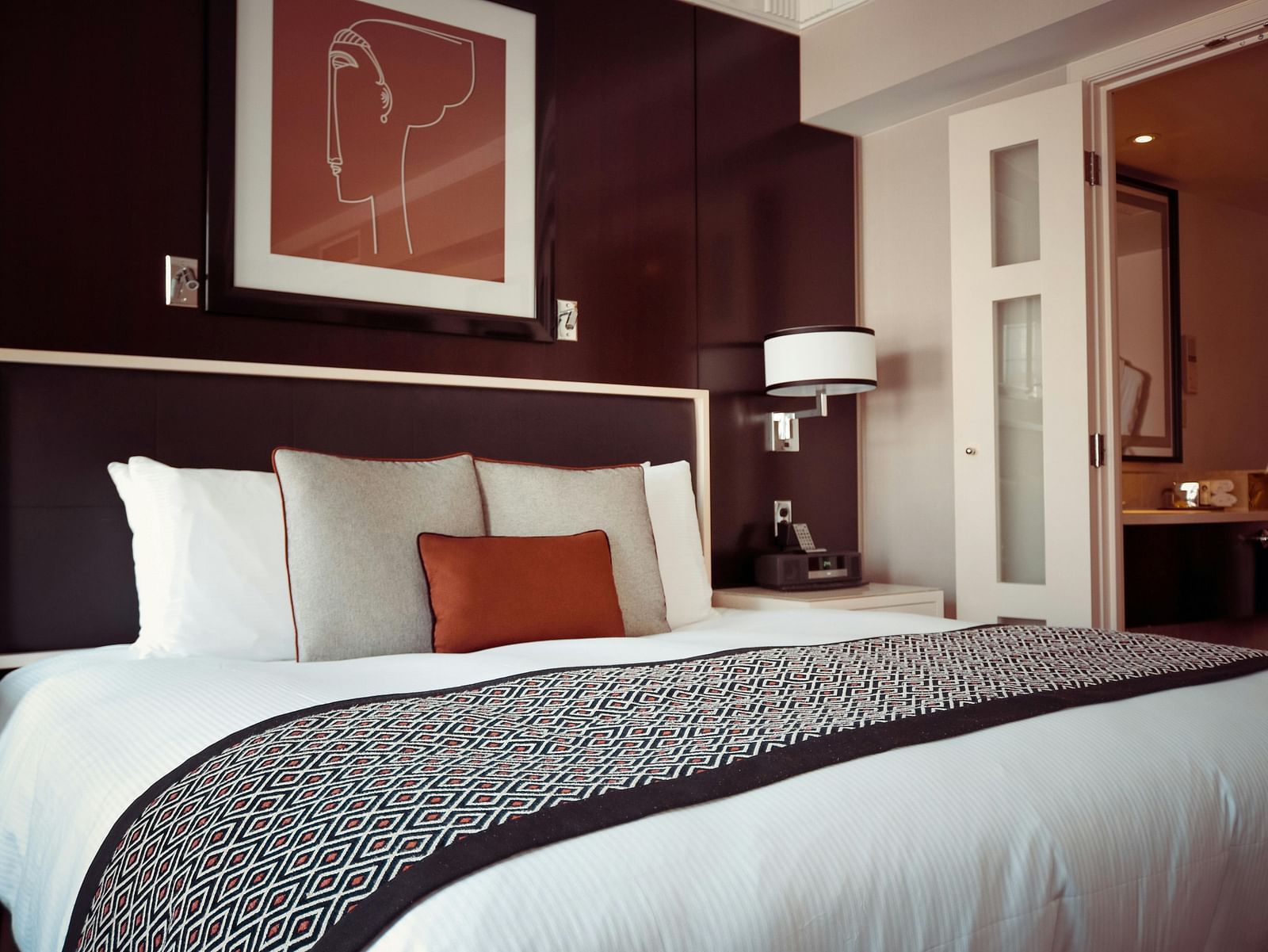 a bedroom with a large bed and a standing lamp in the corner