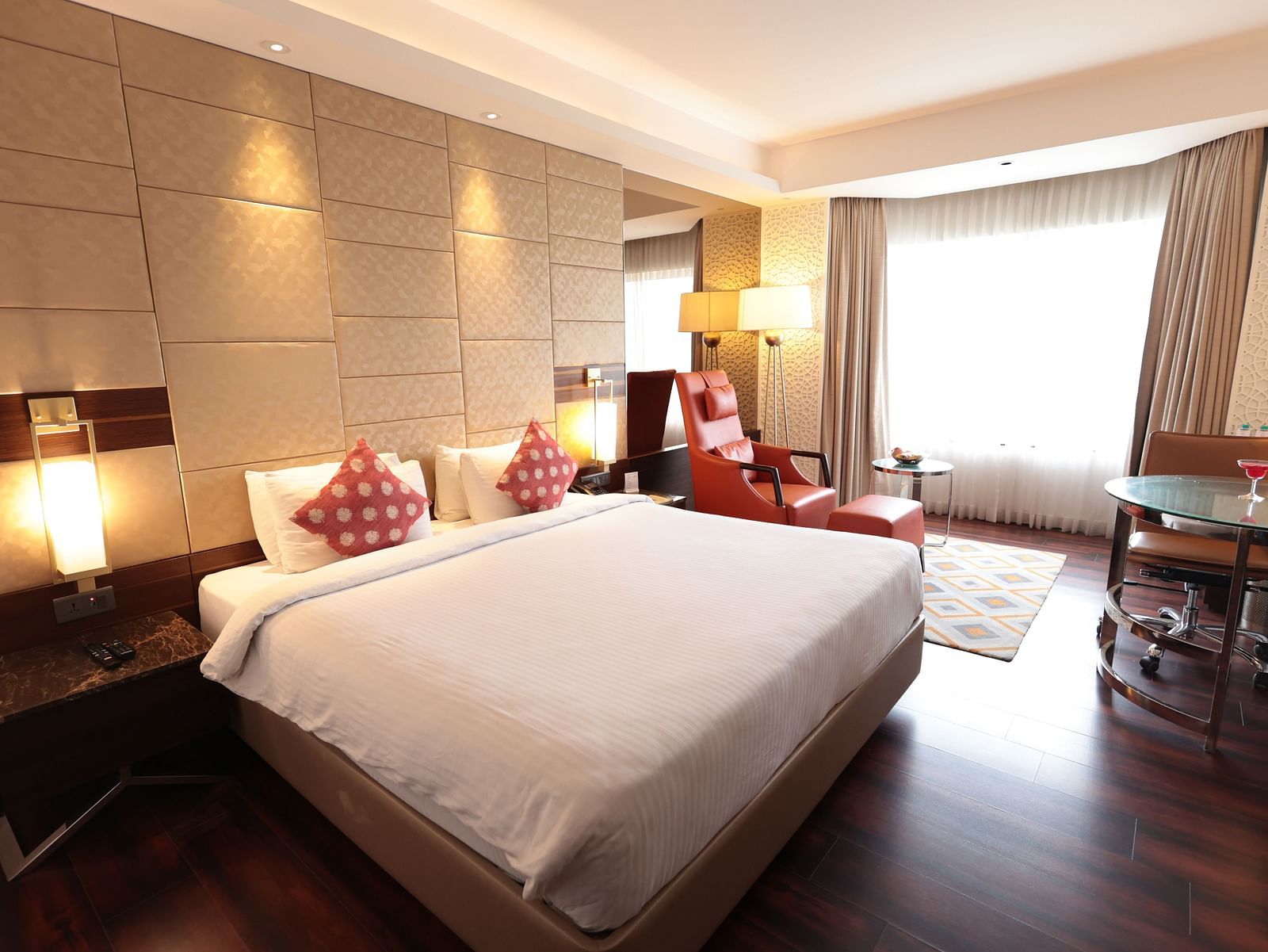 A spacious room with a large bed, a bedside table with a lamp, and curtains pulled to the side of the windows | Cenneys Gateway