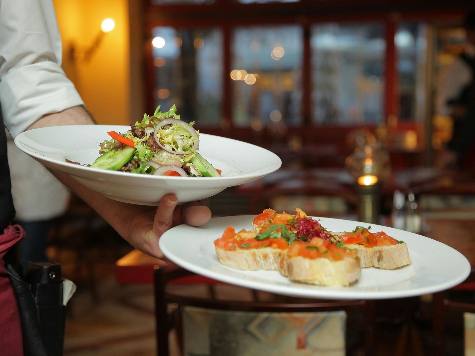 A waiter brings aesthetically arranged food to the table