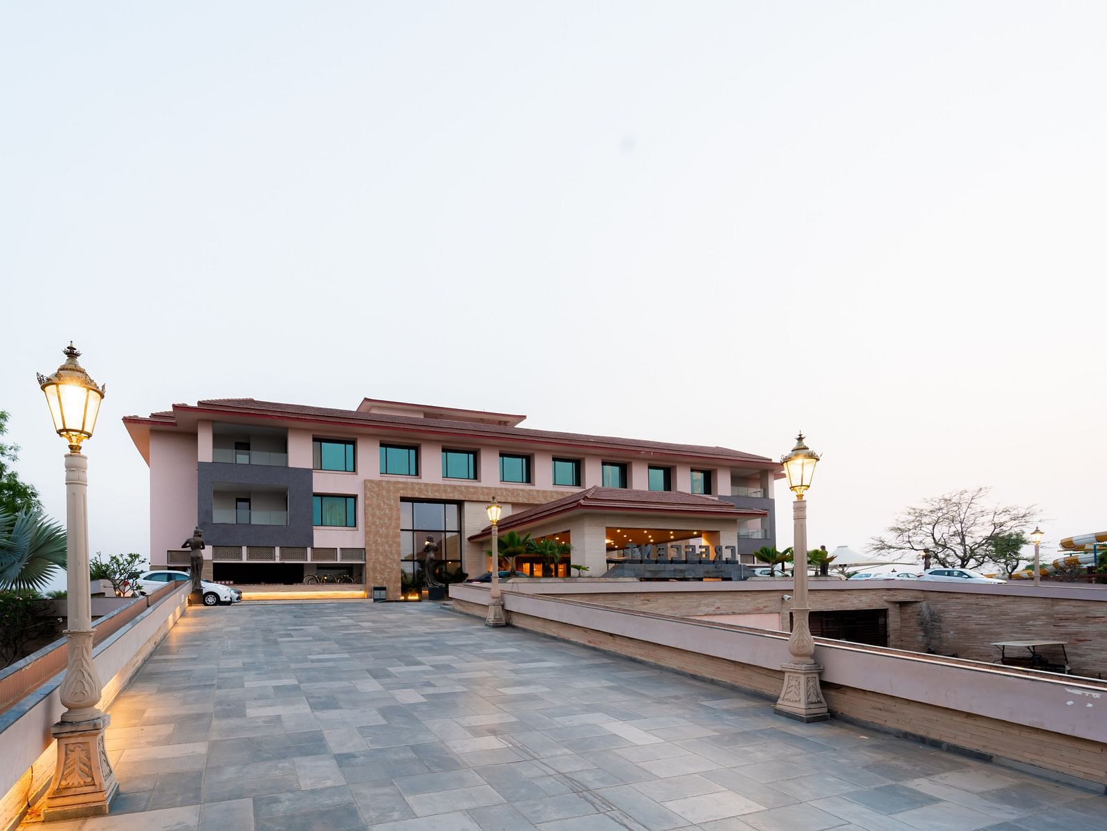 Facade view of Crescent Spa & Resort, Indore, set against a backdrop of a cloudy sky, showcasing its grand architecture