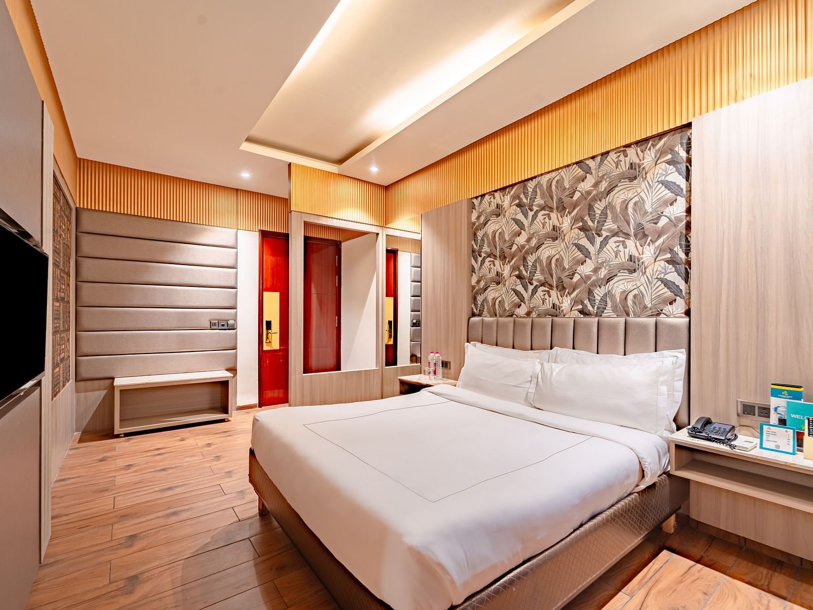 Family Room offers a spacious bed with a bedside table, window curtains, and a wall-mounted television at Crescent Spa & Resort, Indore