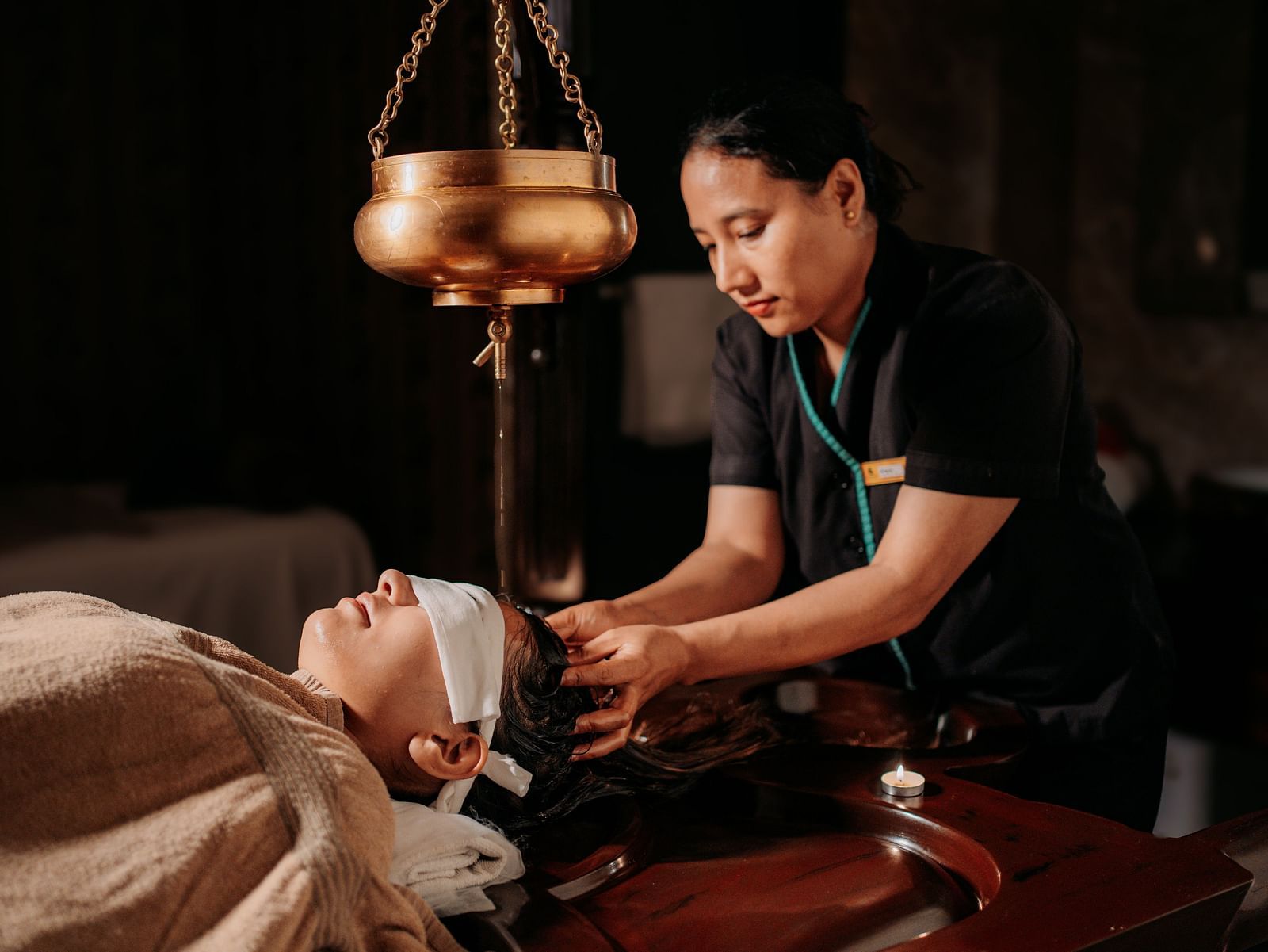 At Crescent spa & resort, Indore, a woman provides a relaxing oil massage to a guest resting on the spa bed