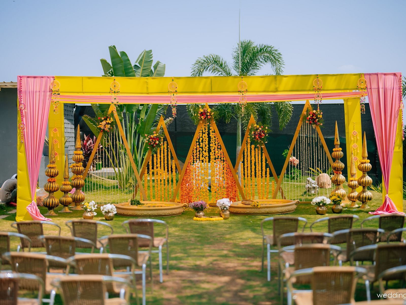image of the decoration of haldi ceremony with several chairs placed facing towards the stage