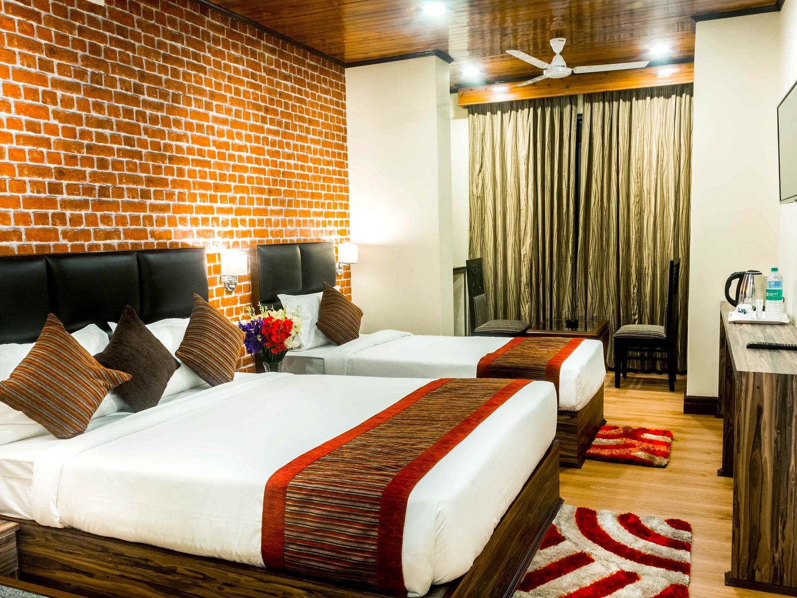 An image of a premium room with with twin beds, bed side tables, flat screen tv, chairs and tables, and other amenities - Ecotel Tin Tin, Bijanbari