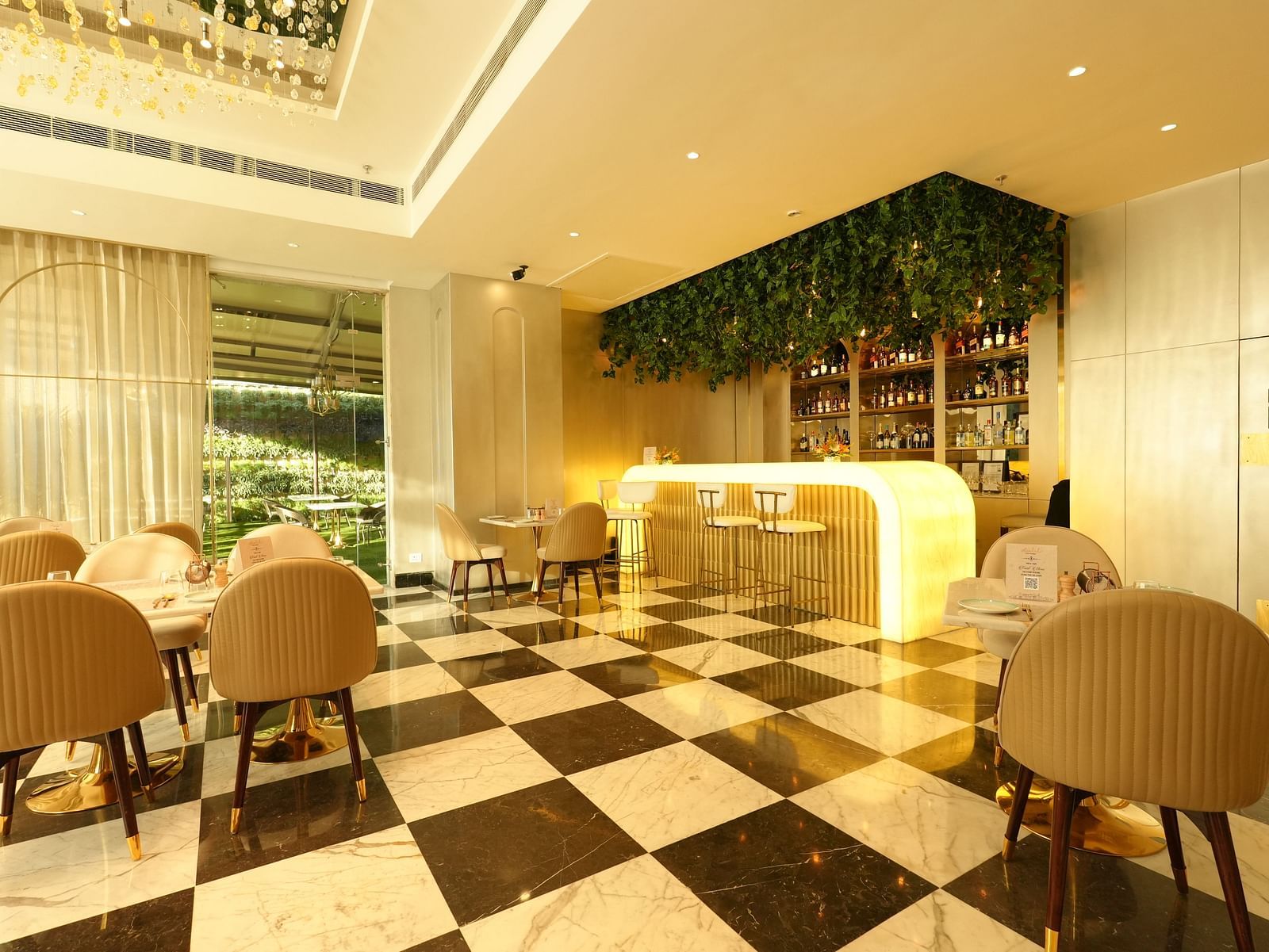 Elegant café-style dining area with beige chairs and sleek flooring - Grand Plaza Lords Inn Jammu