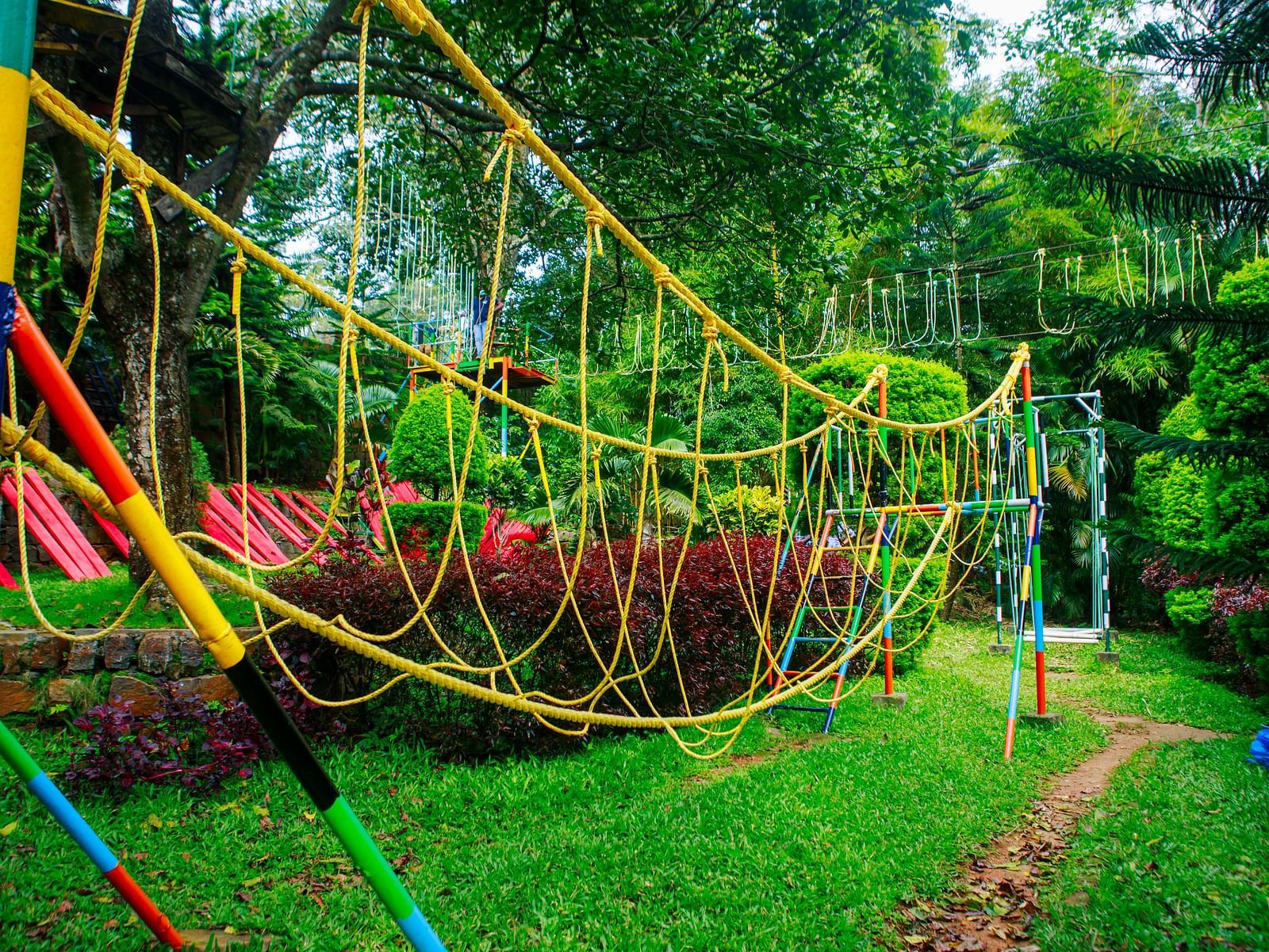 Colourful rope bridge adventure setup nestled within lush greenery at GReaT Trails Yercaud by GRT Hotels, one of the premier team building venues in Yercaud, offering outdoor activities perfect for group bonding and corporate retreats.