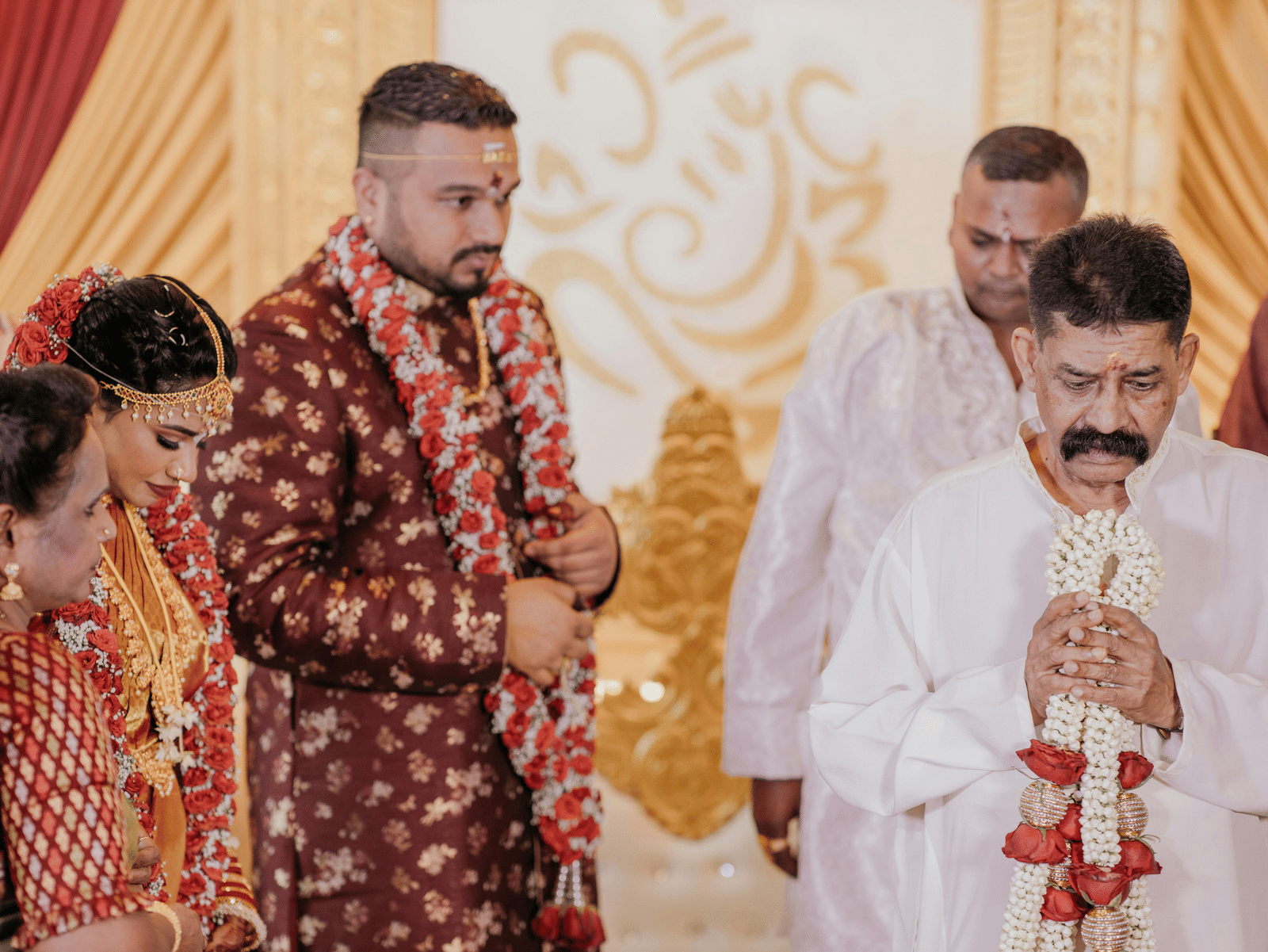 The groom and family stand together during a traditional Indian marriage ceremony.