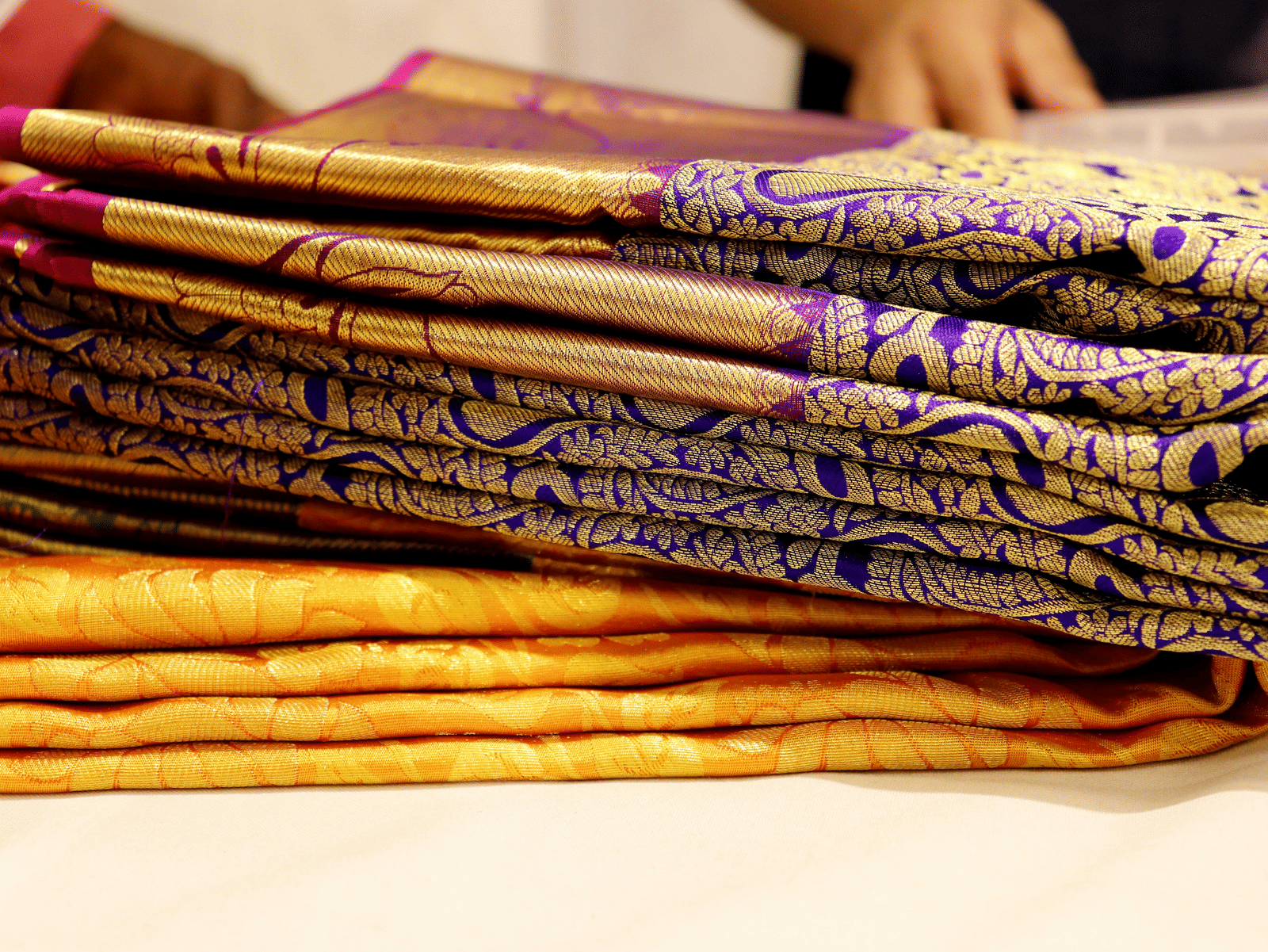 A collection of traditional sarees with intricate patterns and designs in many colours.