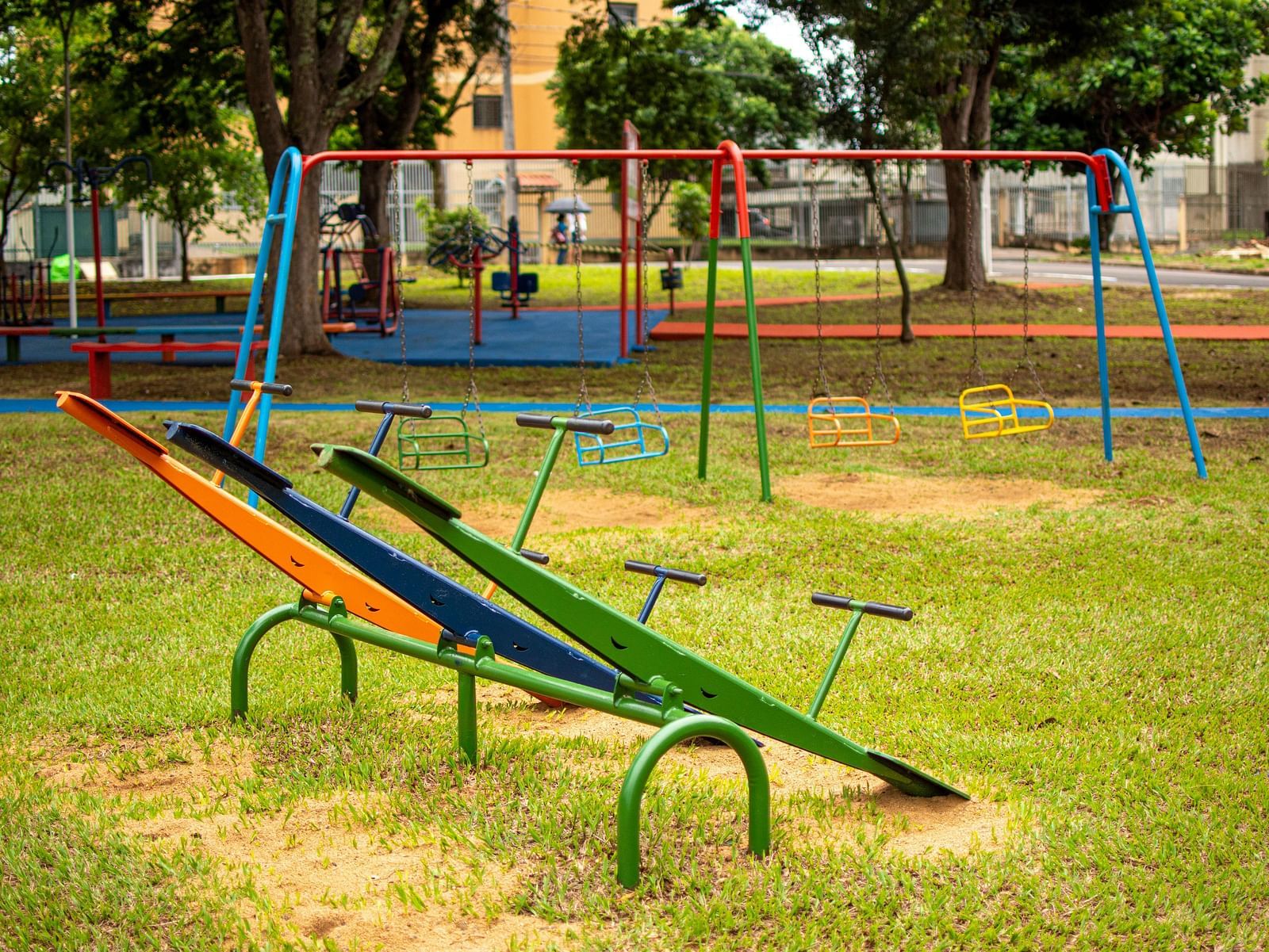 Empty playground with swings and seesaws.