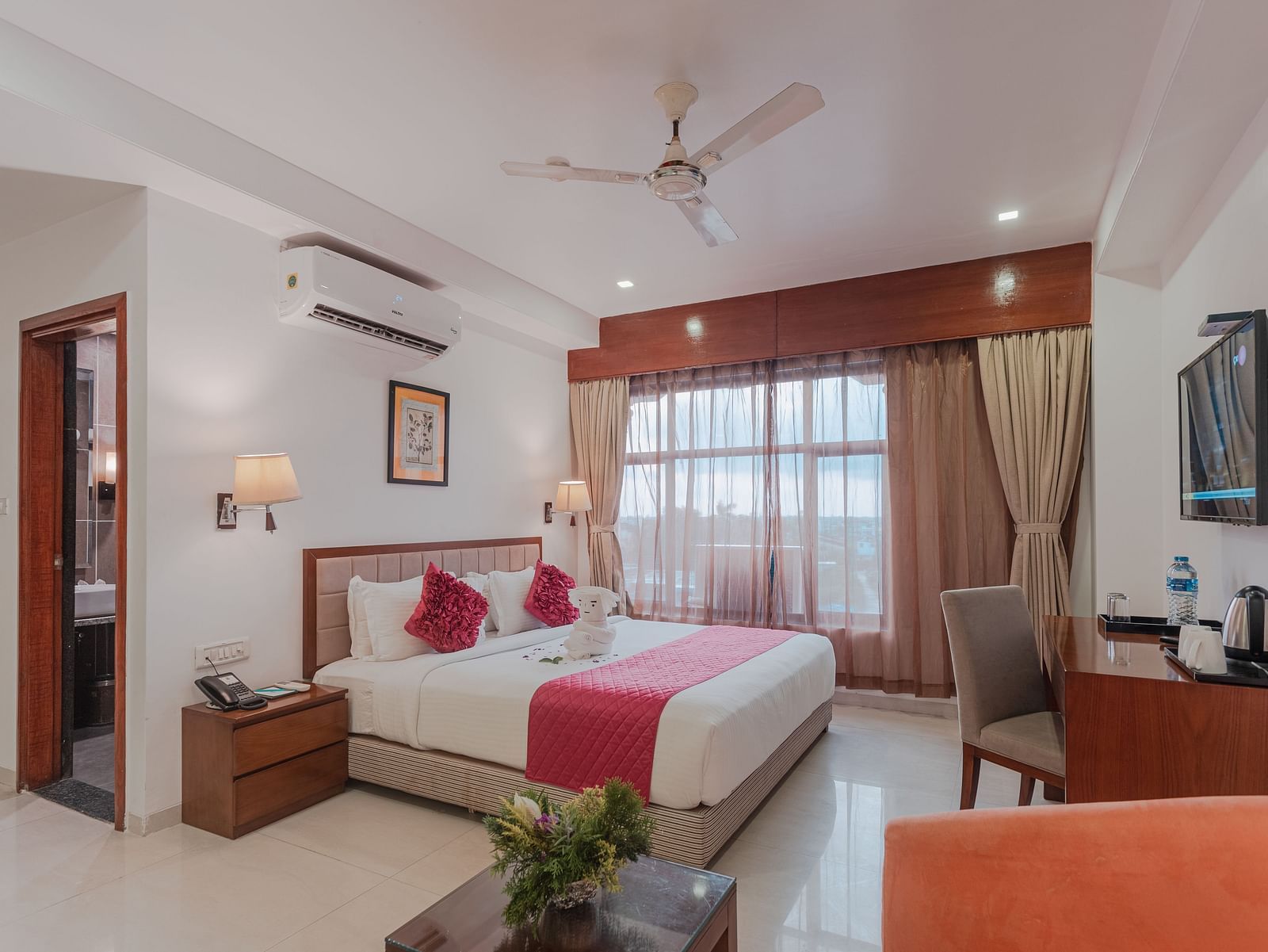 Comfortable hotel room at Diamond Palace Lords Plaza with a double bed, seating area, mounted TV, and air conditioning.