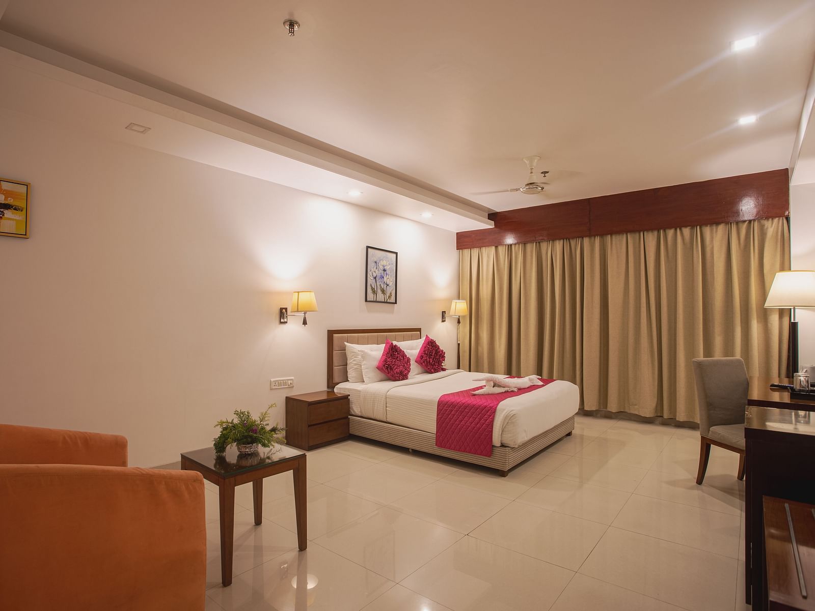 Comfortable hotel room at Diamond Palace Lords Plaza with a double bed, seating area, work desk, and a large window.