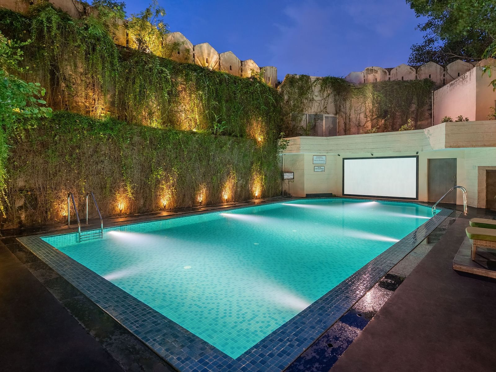 Shot of the swimming pool at the hotel in the evening with well lit surroundings - Hotel Rajdarshan, Udaipur.