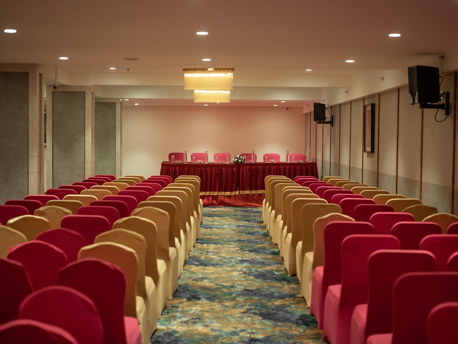 Event hall with rows of red and beige chairs arranged for a meeting at Hotel Royal Regency Chennai