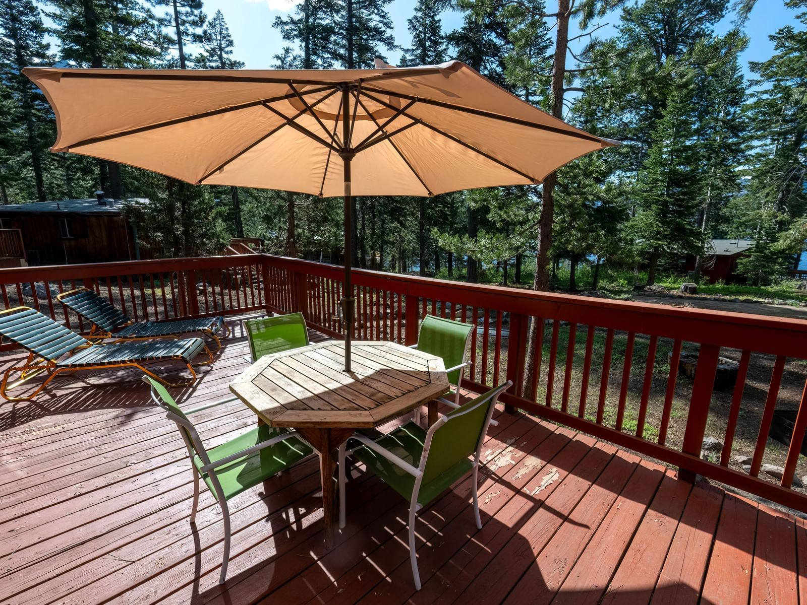 Outdoor deck with umbrella, table, and forest views at Kit Carson Lodge.