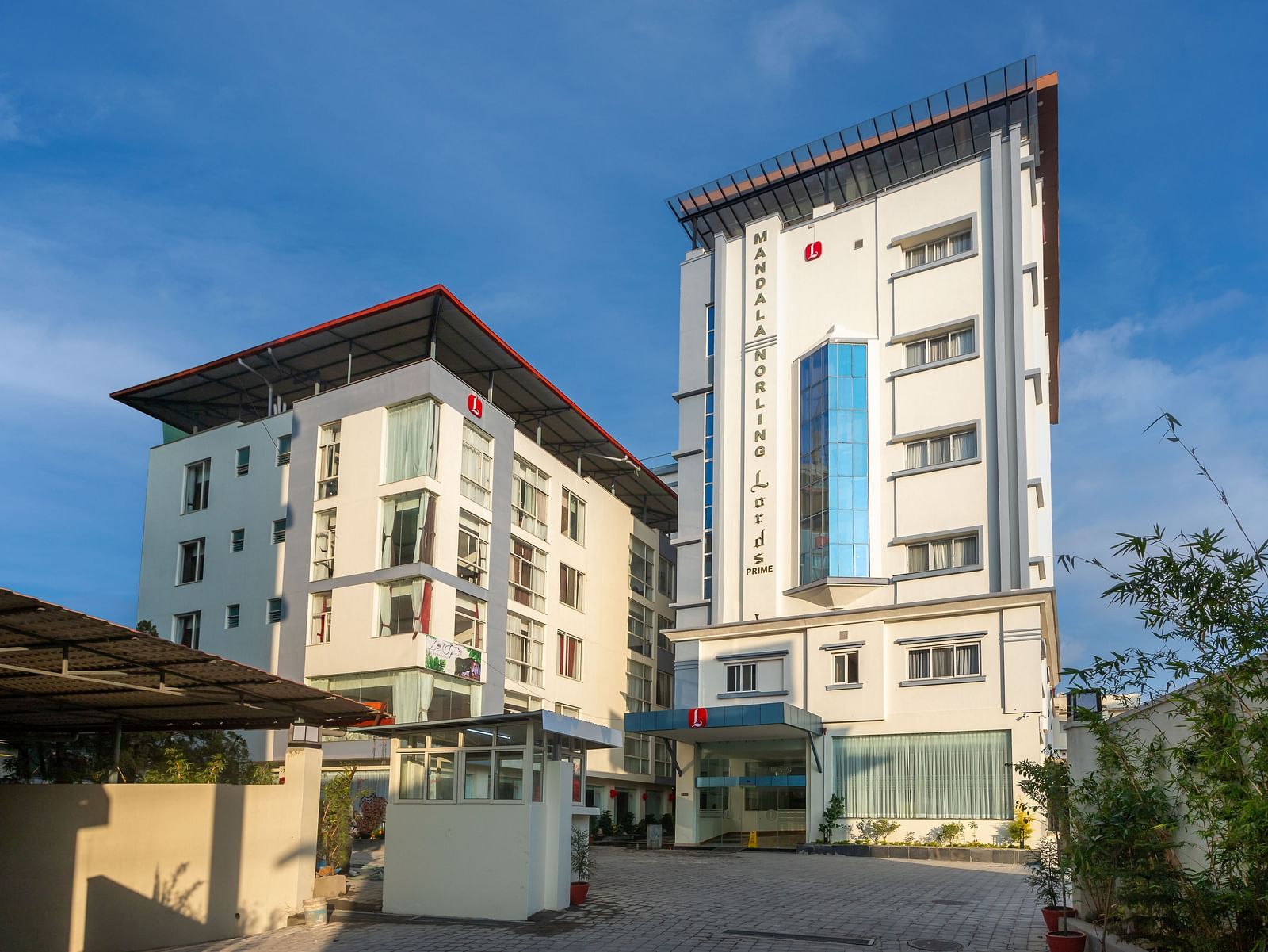 Facade of the two buildings in Mandala Norling Lords Prime in Kathmandu with a driveway on a sunny day.