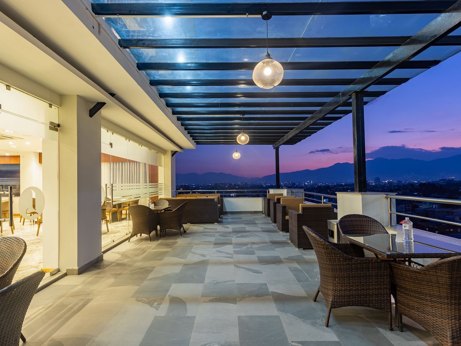 Outdoor seating arrangement at Mandala by Lords featuring a spacious corridor with a covered ceiling and picturesque views.