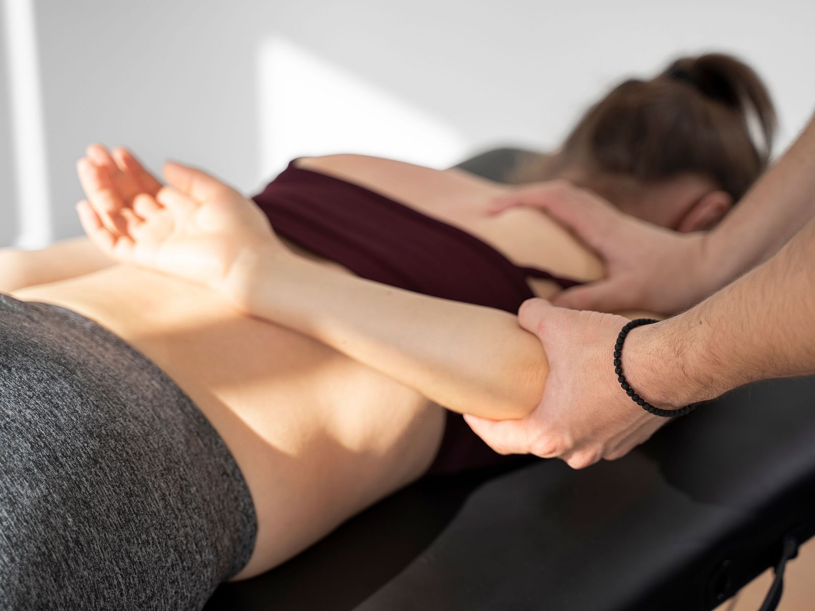 A physiotherapist assisting a patient with an arm stretch during a recovery session.