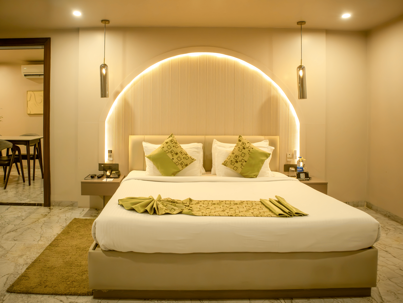 Side view of one of the accommodations at Papaya Tree Hotels showcasing ample lighting, double bed, and a door opening to another room.