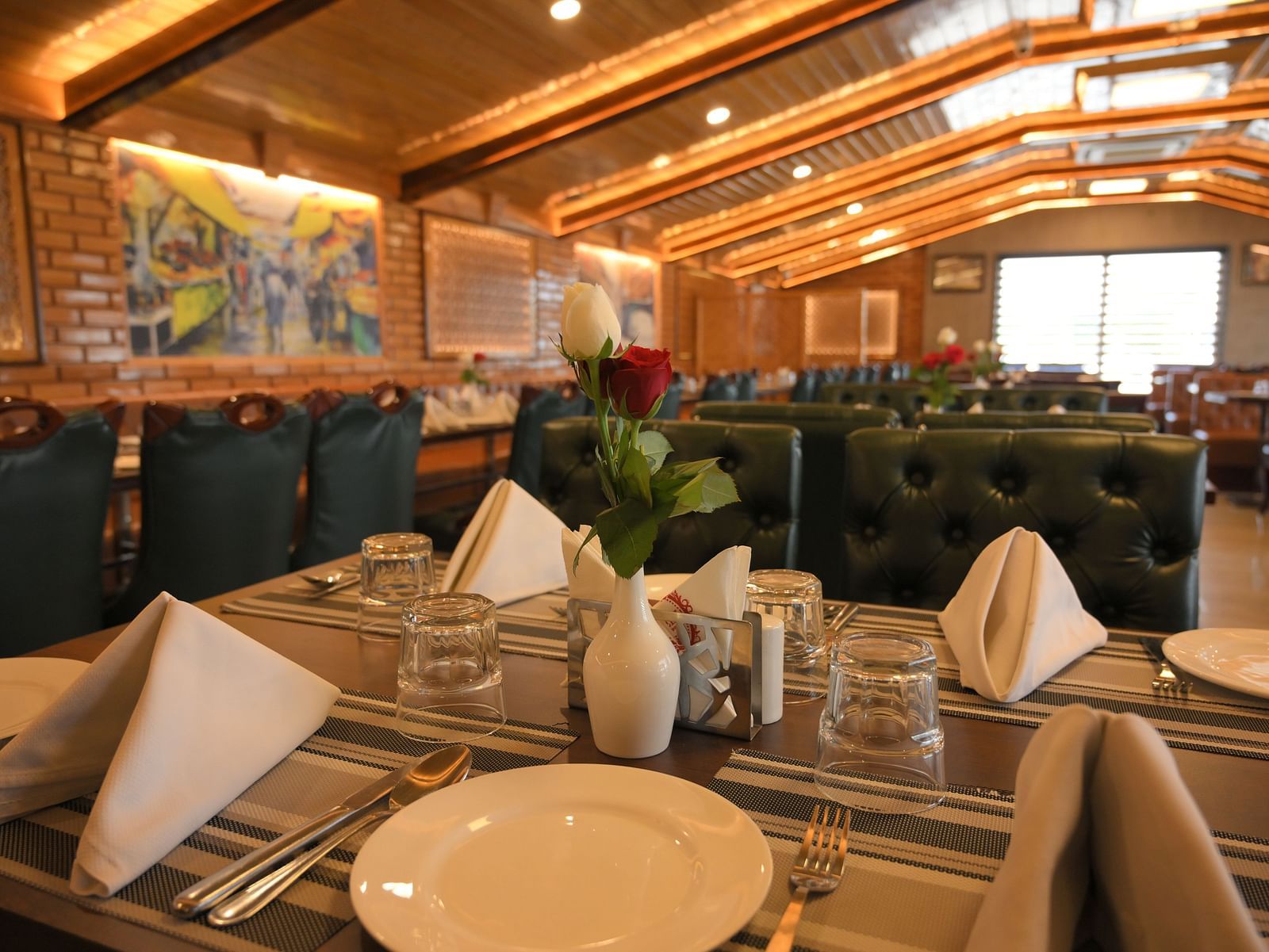 Elegant dining table setup with crisp napkins and warm lighting at Royal Comfort Regency, perfect for a refined dining experience.