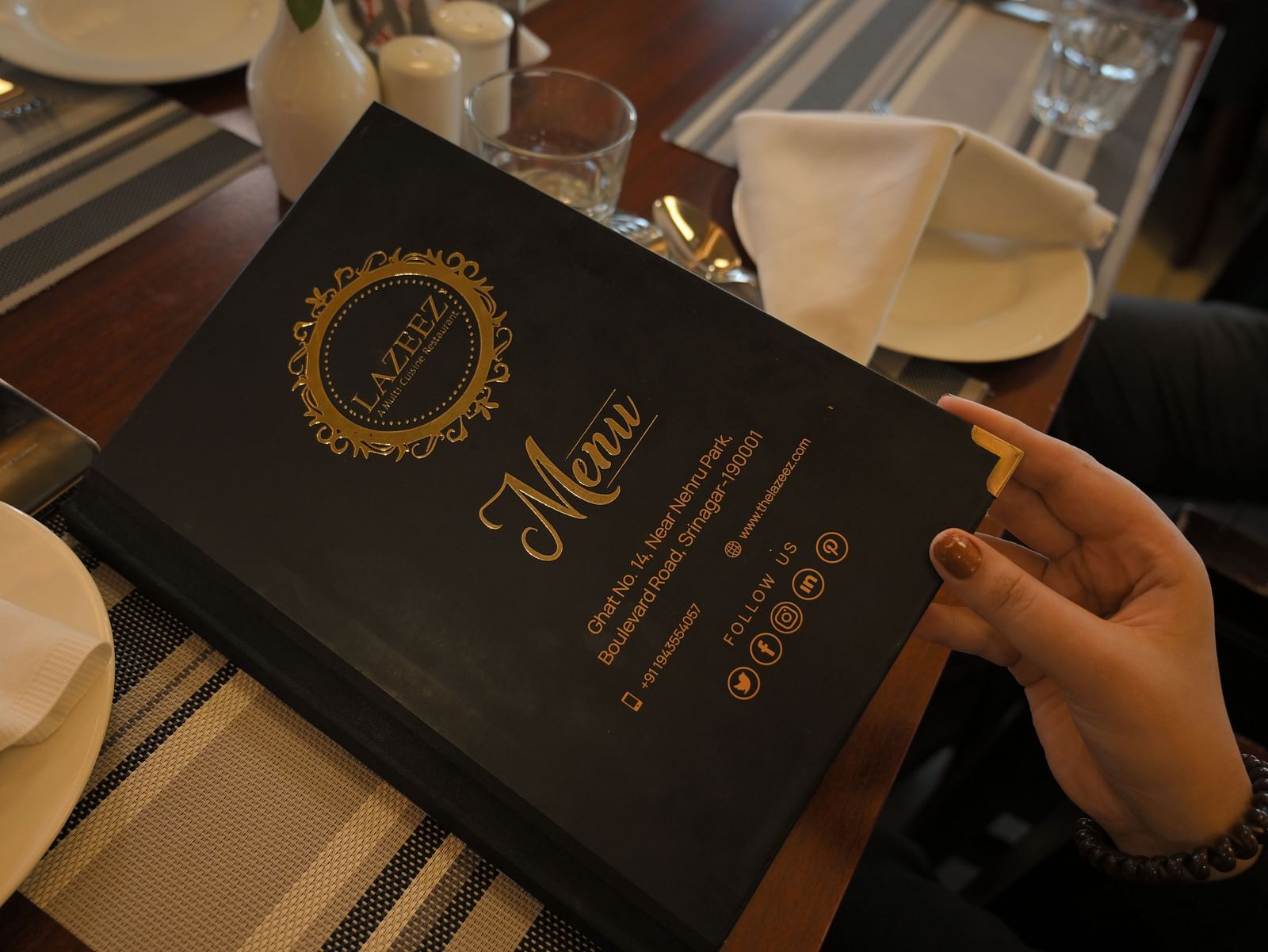 Guest holding the menu at Royal Comfort Regency highlighting a curated selection of dishes for a premium dining experience.