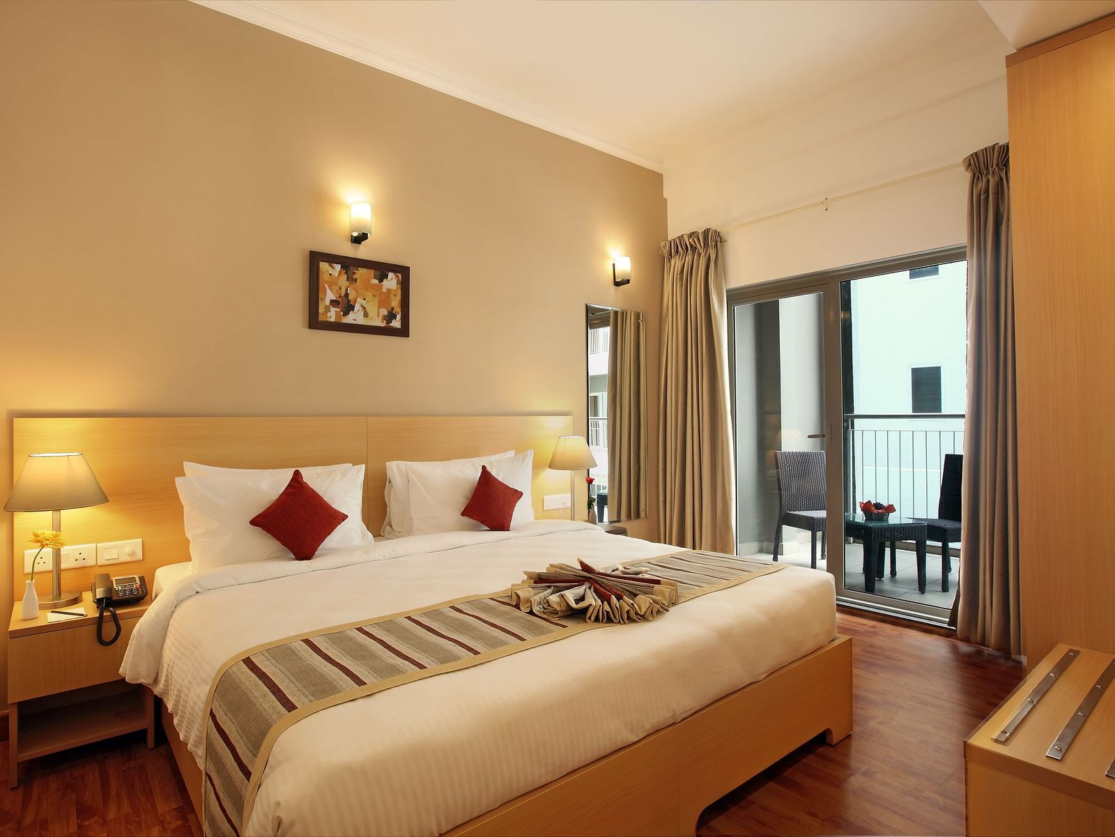 A double bed with side tables and lamps inside Deluxe Room - Starlit Suites, Kochi
