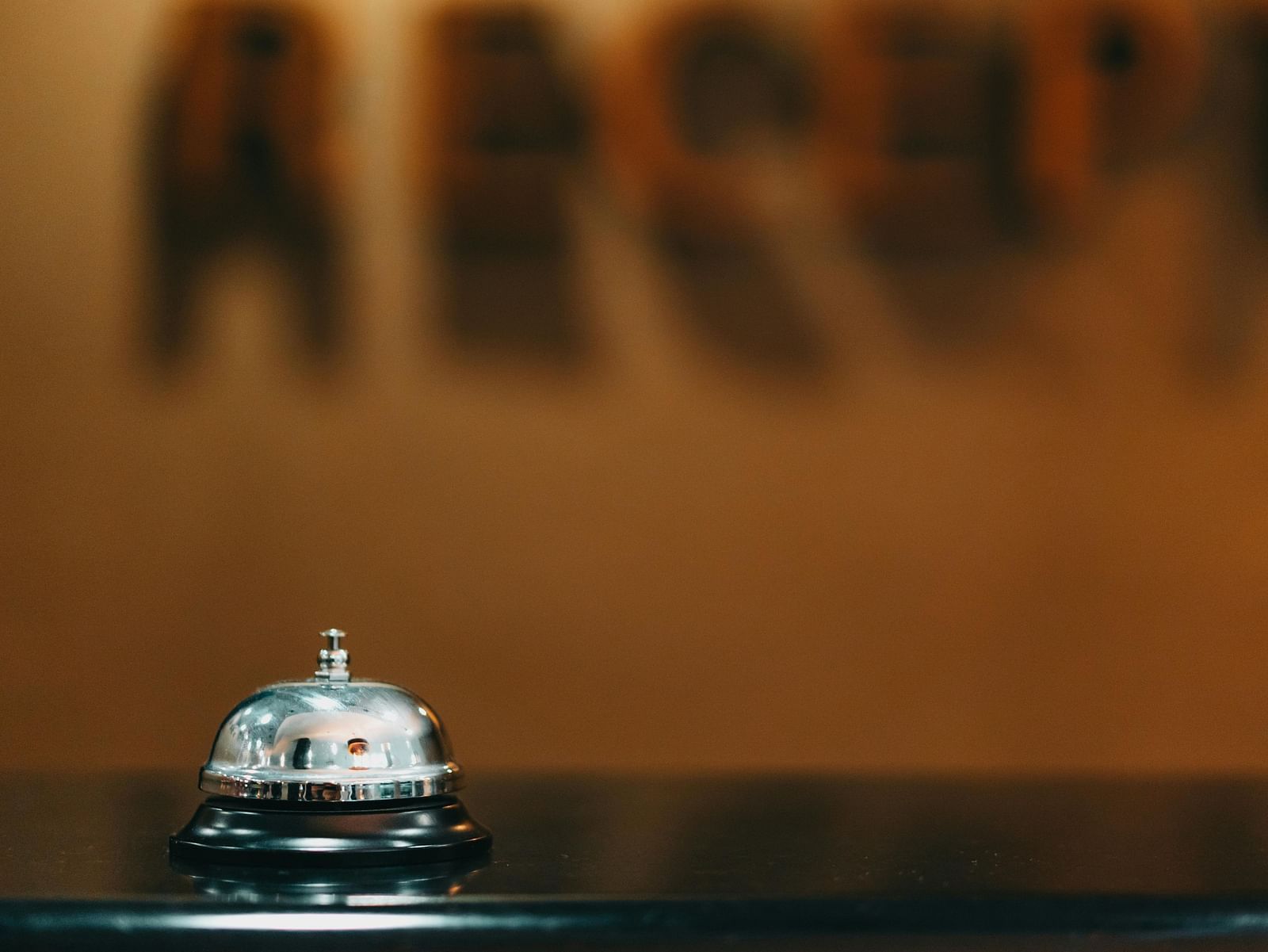 A sliver coloured bell placed on a flat surface.