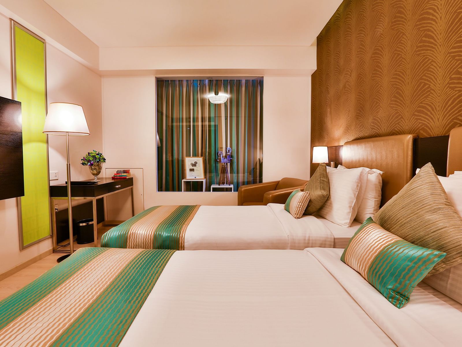 A room with twin beds, standing lamp and a work desk and chair at T24 Residency, Andheri East, Mumbai