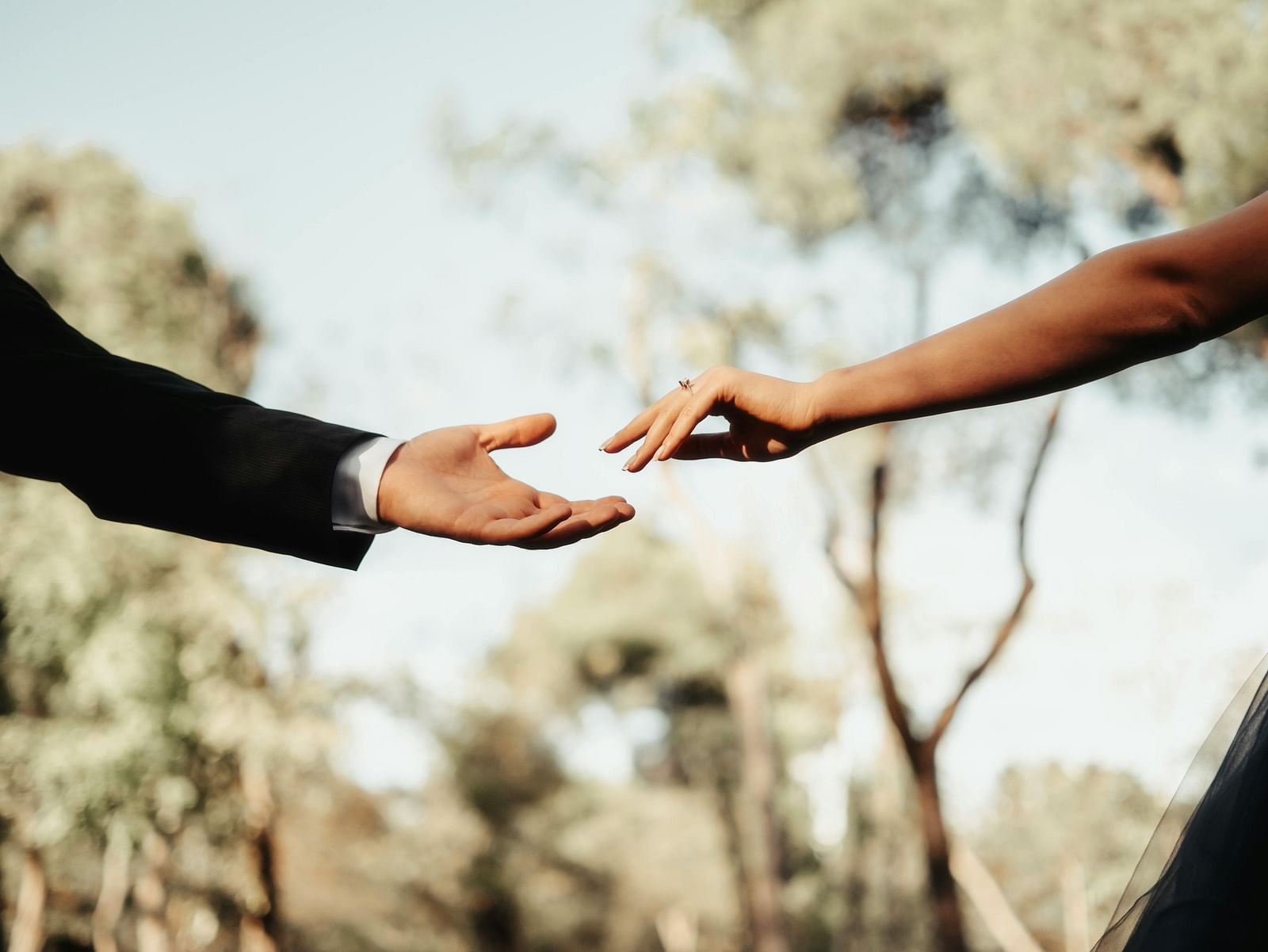 two hands reaching out to each other during a photoshoot - The Groveland Hotel.