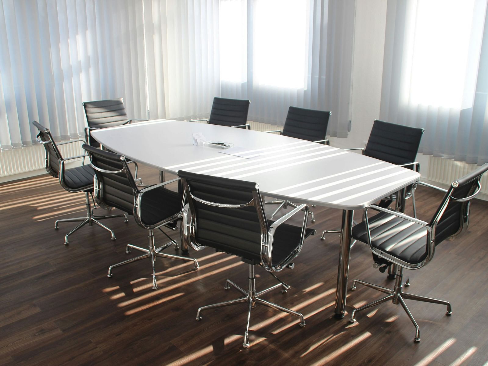 Boardroom with broad table and chairs arranged around it